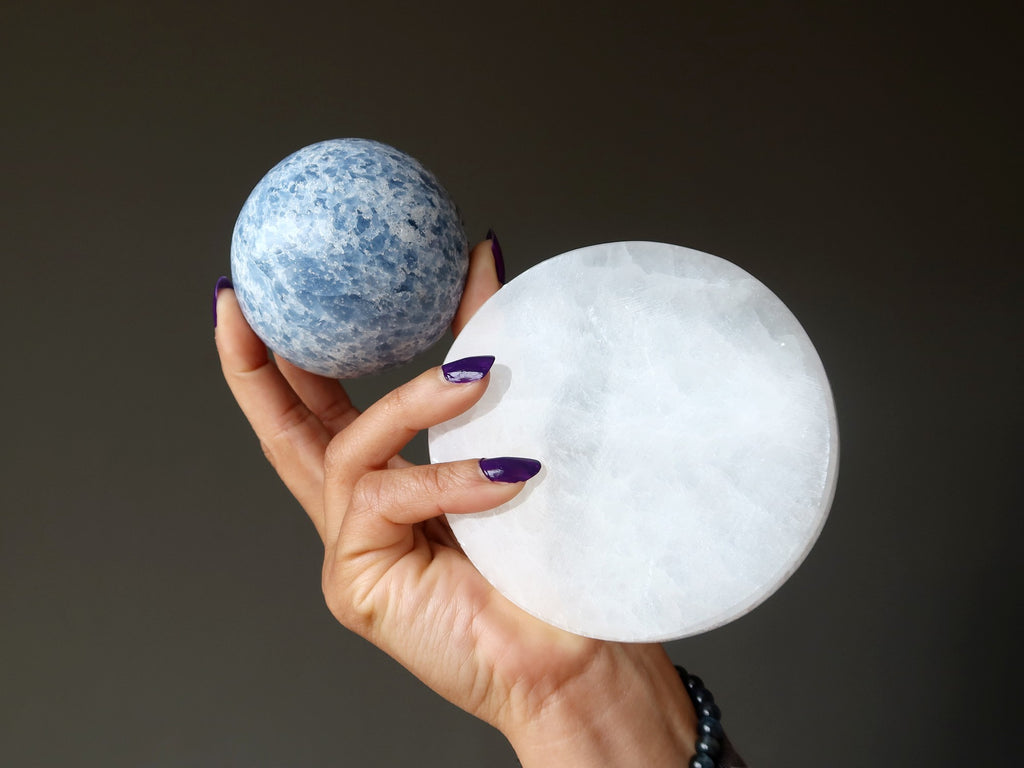 hand holding blue calcite sphere and selenite circle 