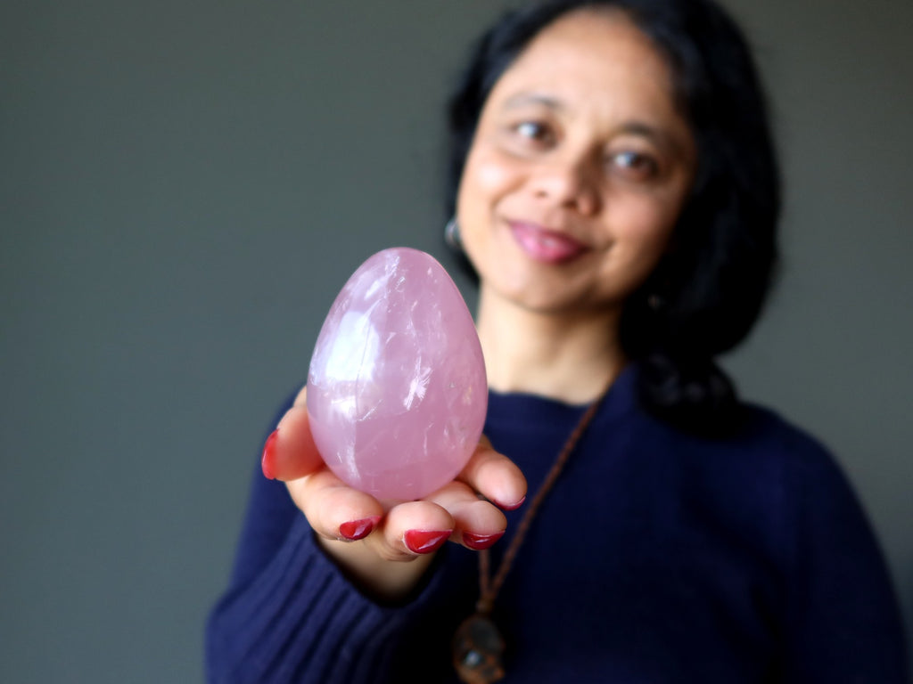 woman holding rose quartz crystal egg