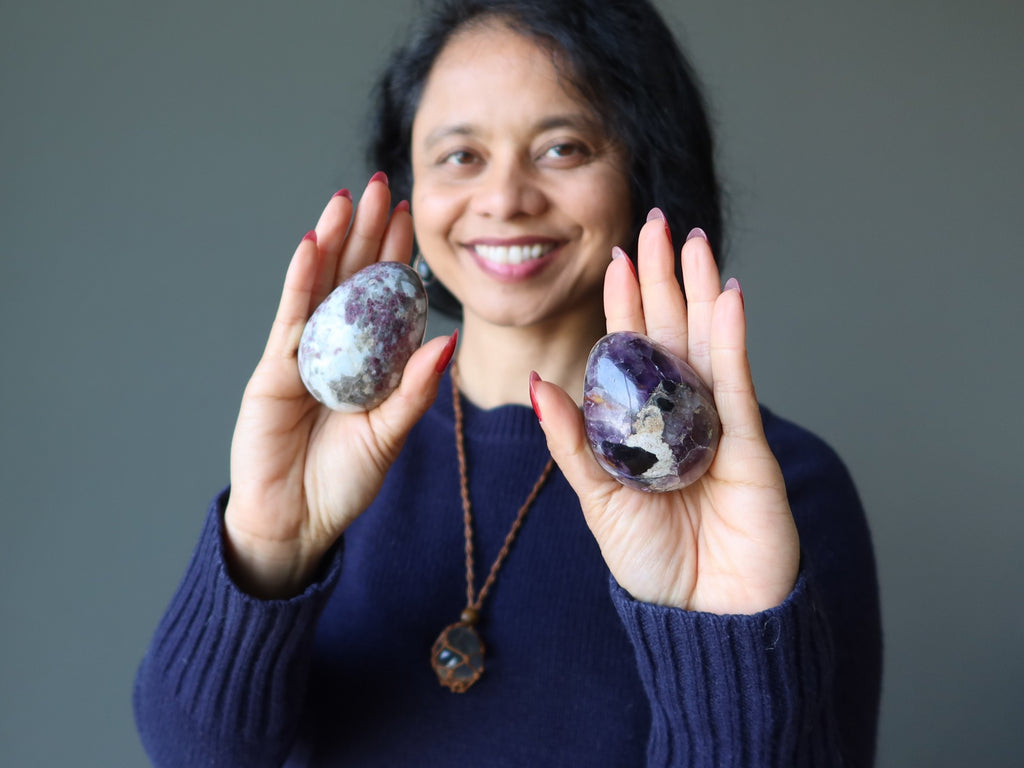 woman holding tourmaline and amethyst eggs