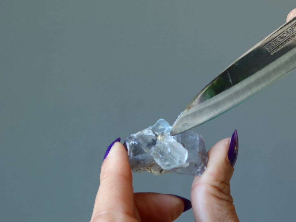 stainless steel knife scratching raw fluorite