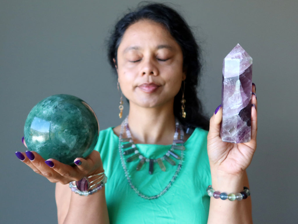 woman meditating with fluorite sphere and tower