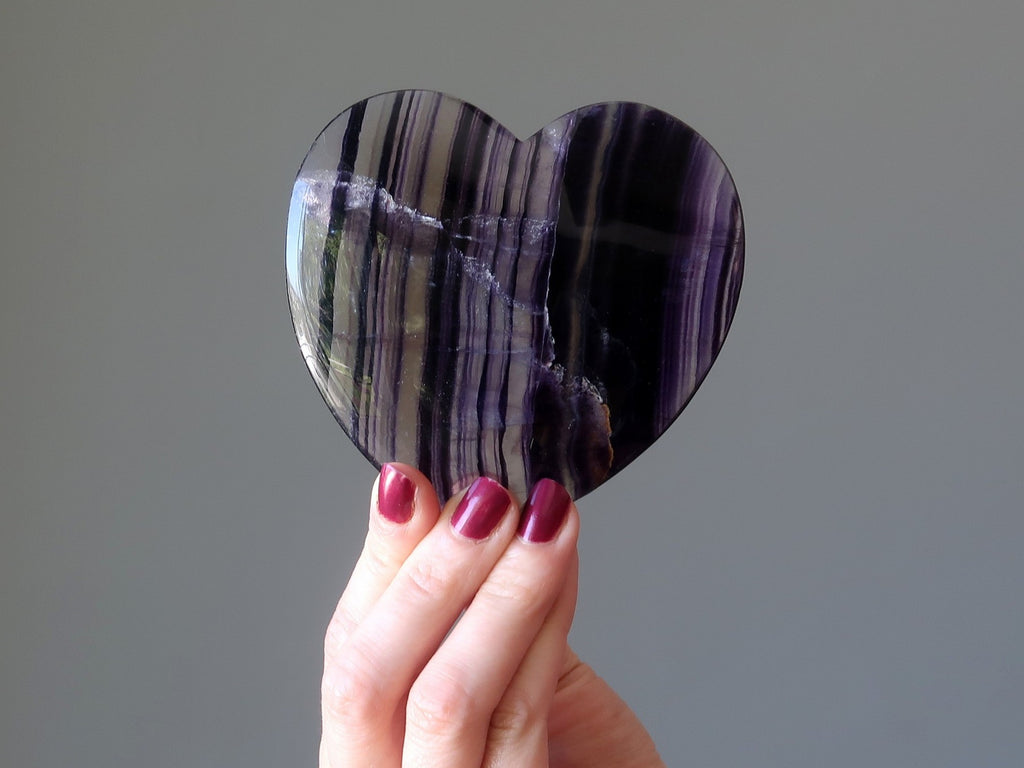 hand holding purple fluorite heart