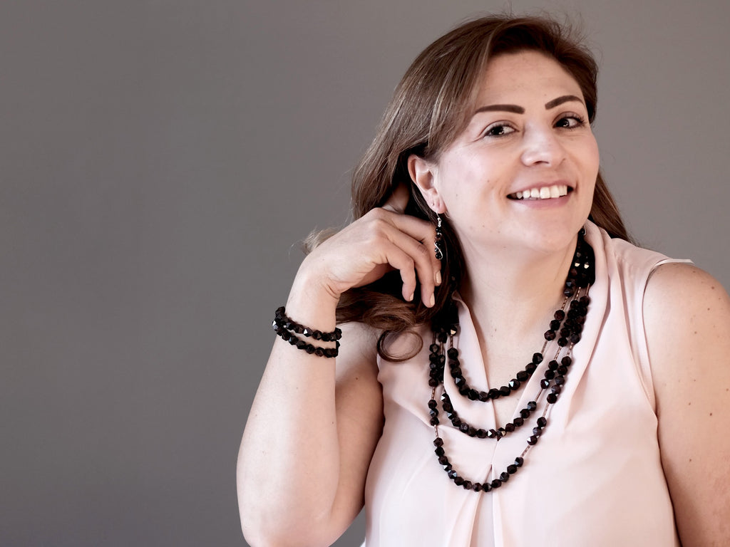 woman modeling faceted garnet earrings, necklaces, bracelets