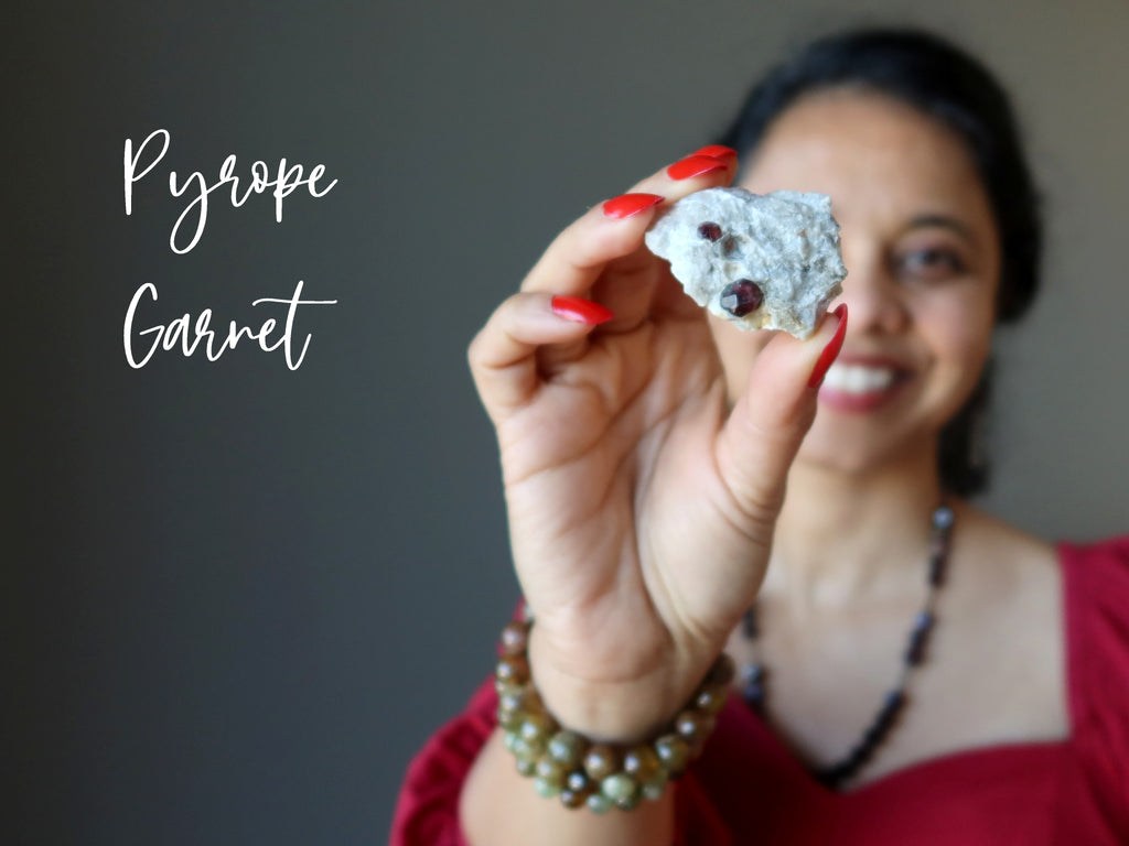 sheila of satin crystals holding a pyrope garnet cluster