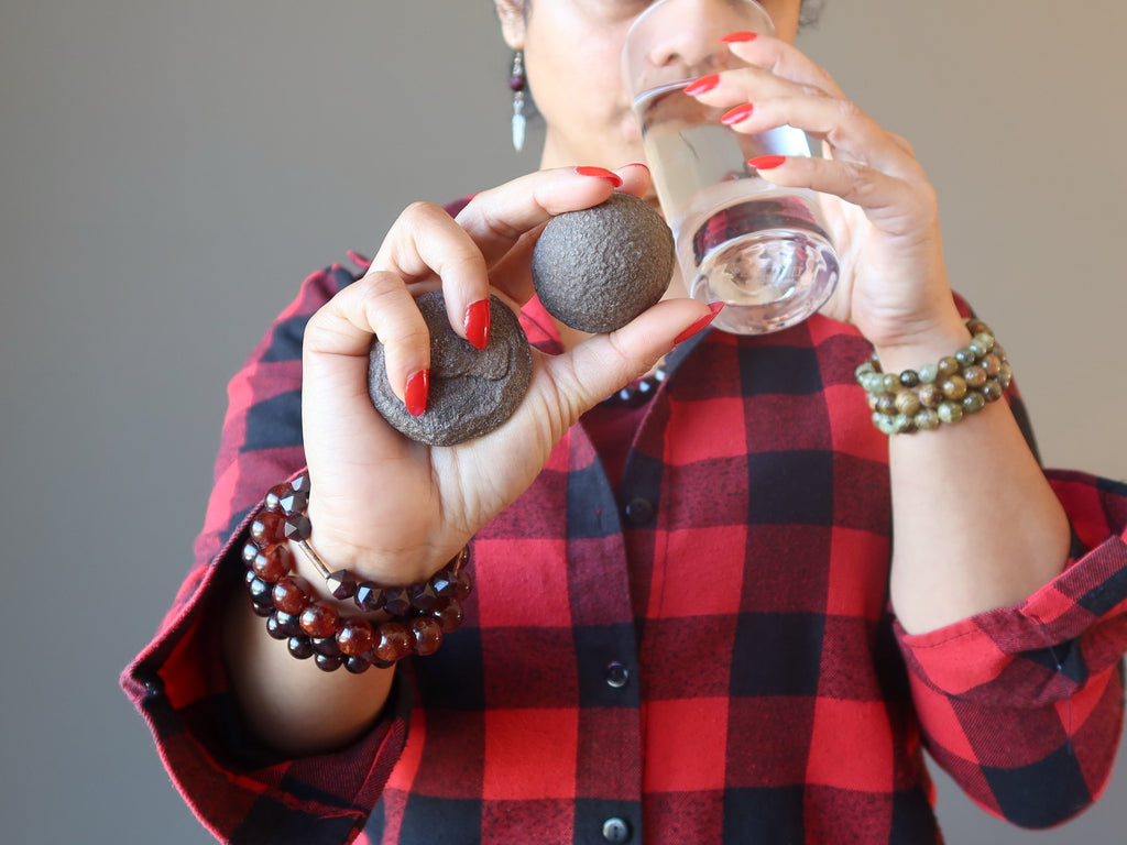 woman drinking water and holding moqui marbles