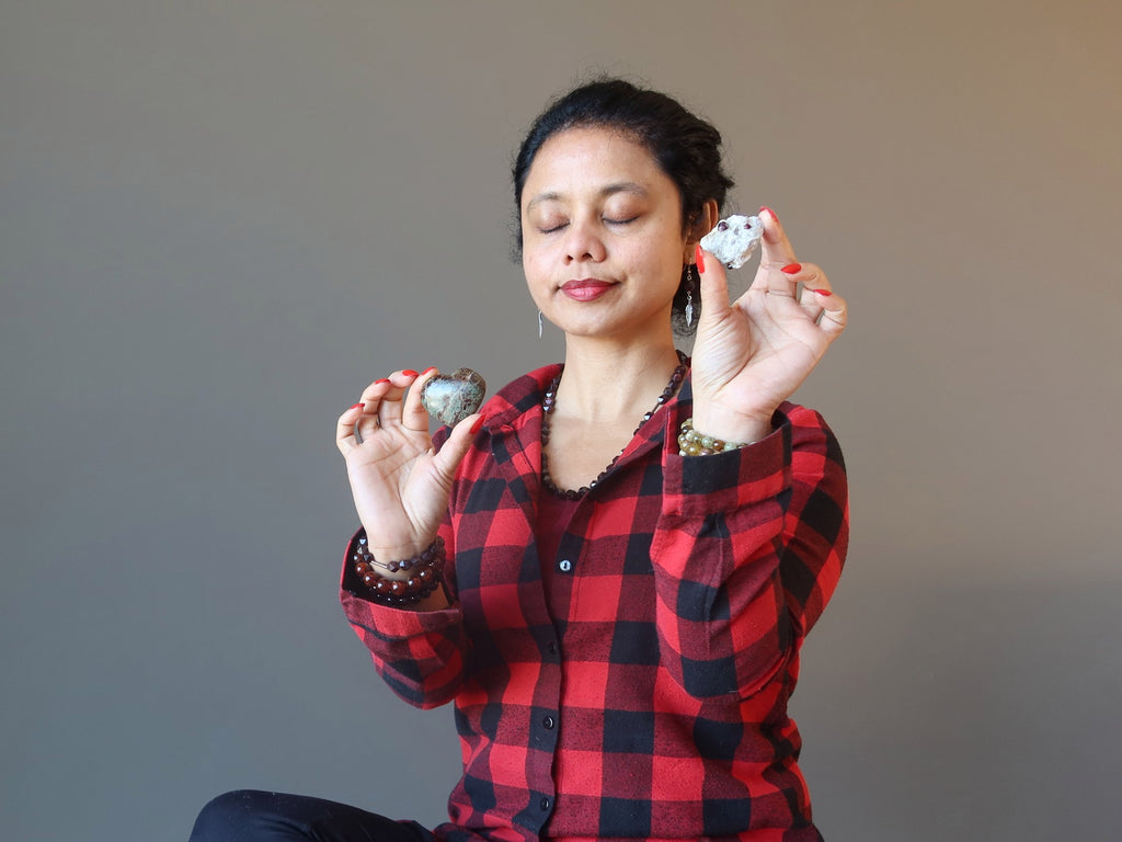 woman meditating with raw garnet clusters