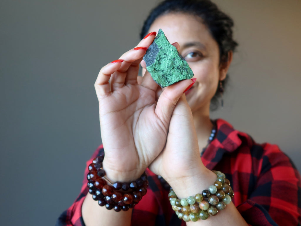 woman holding green uvarovite garnet raw stone