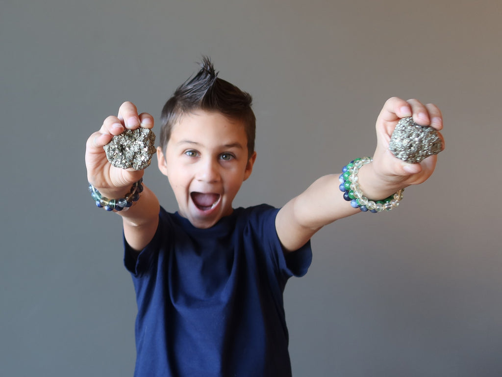 boy holding raw pyrite clusters