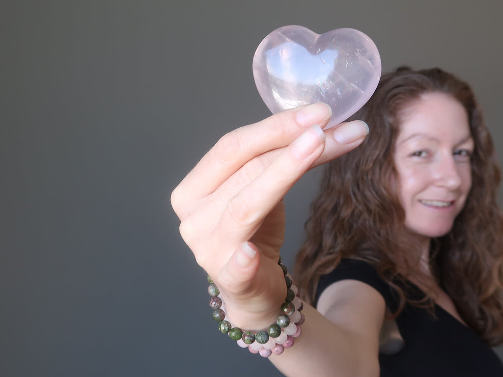jamie of satin crystals holding up a pink rose quartz stone heart for healing