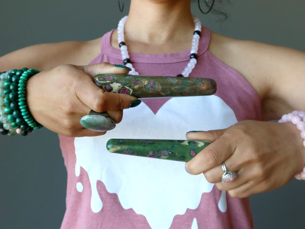 sheila of satin crystals using ruby zoisite massage wands to show the heart chakra location
