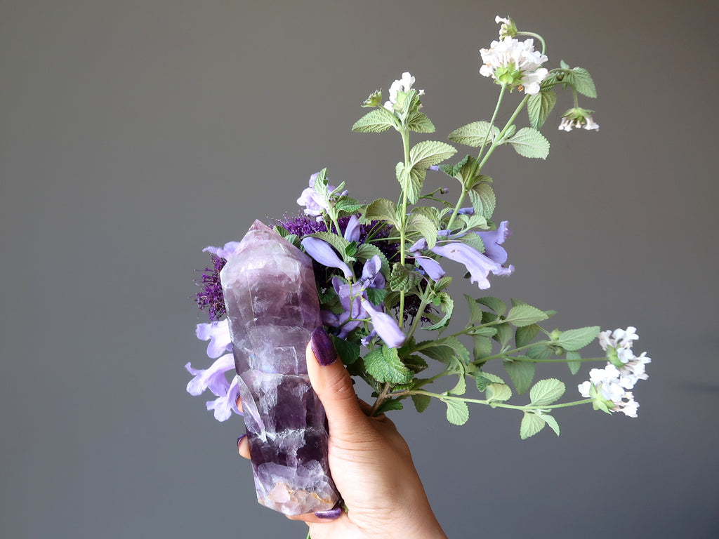 hand holding purple fluorite tower and flowers