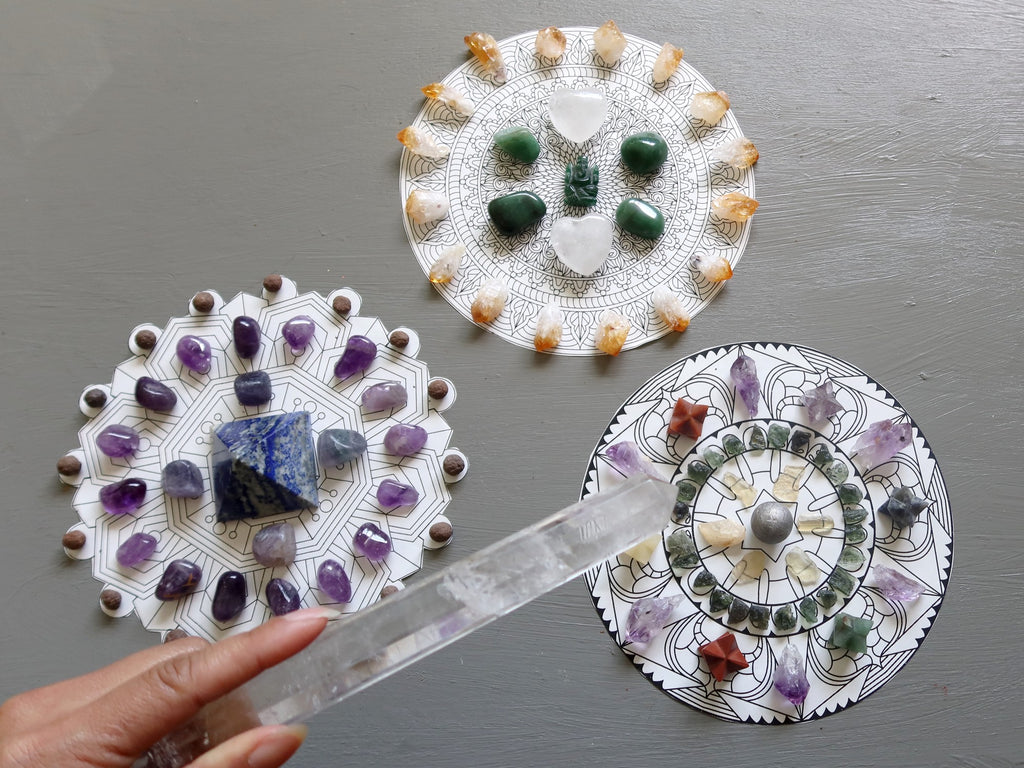 three mandalas being activated with a clear quartz wand