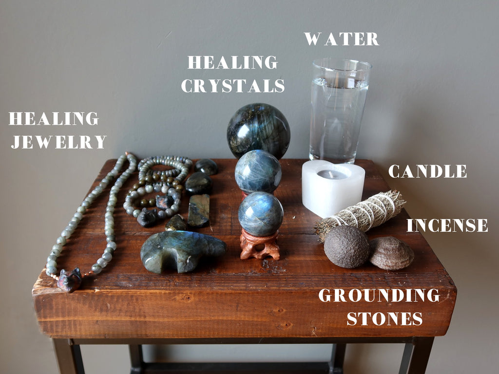 jewelry, crystals, water, candle, sage, grounding stones for meditation