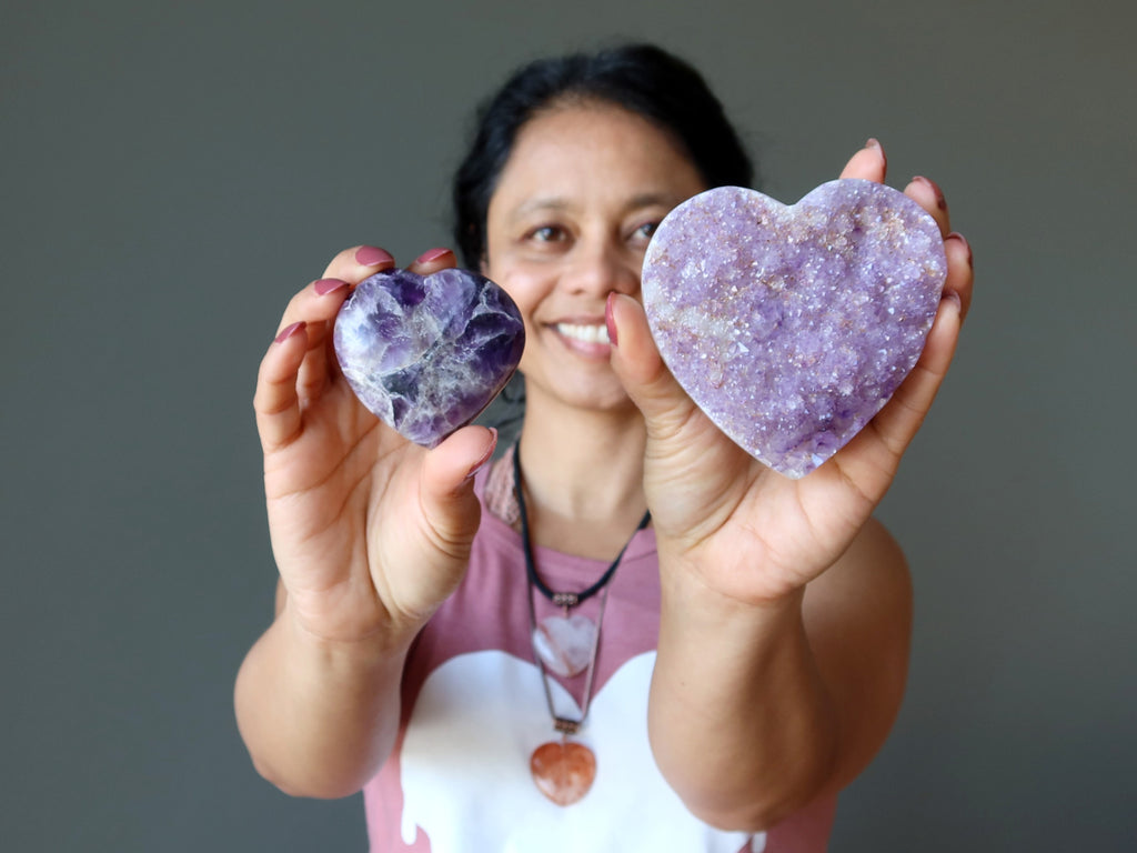 woman holding amethyst hearts