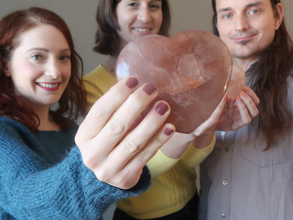 two woman and man with a red quartz heart