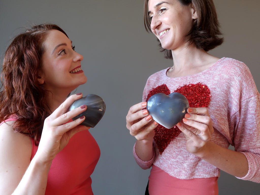 two ladies holding blue lace agate crystal hearts