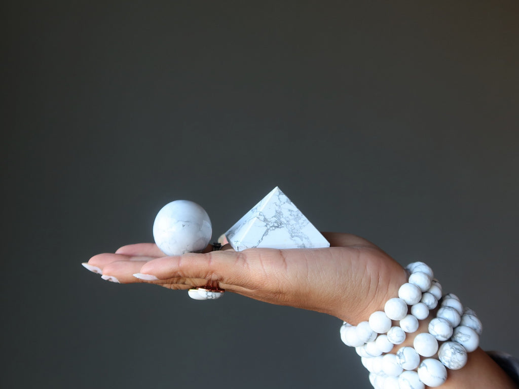 hand wearing and holding howlite stones