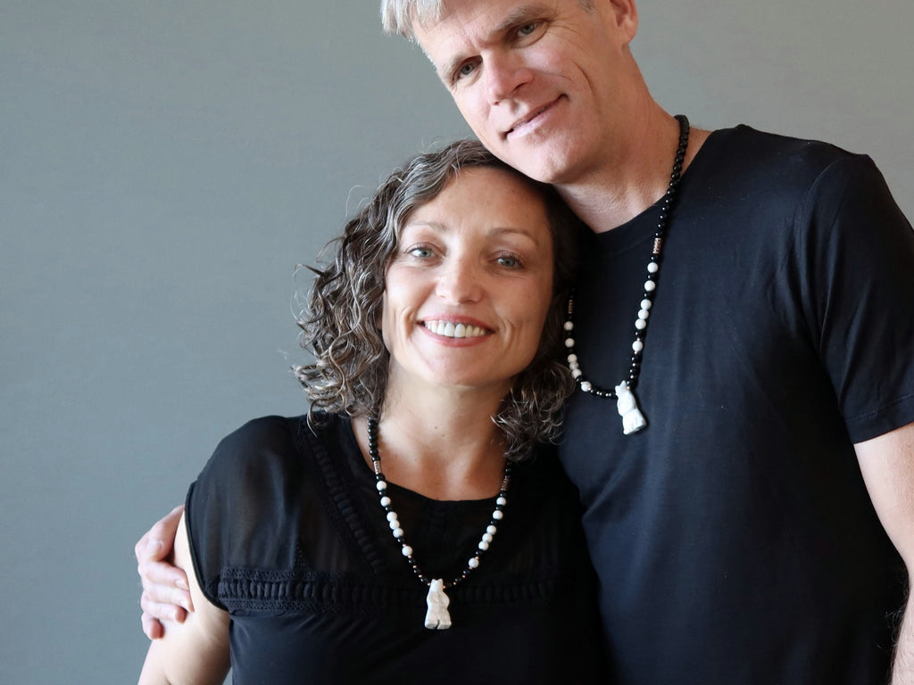 man and woman wearing howlite bear necklaces