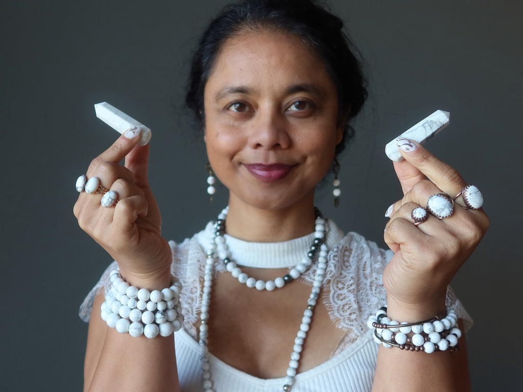 sheila of satin crystals holding two howlite wands pointed away from her