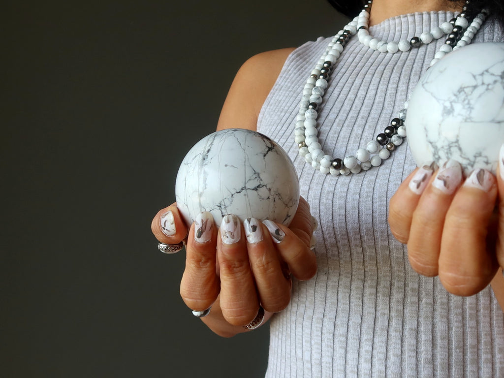 woman holding howlite spheres