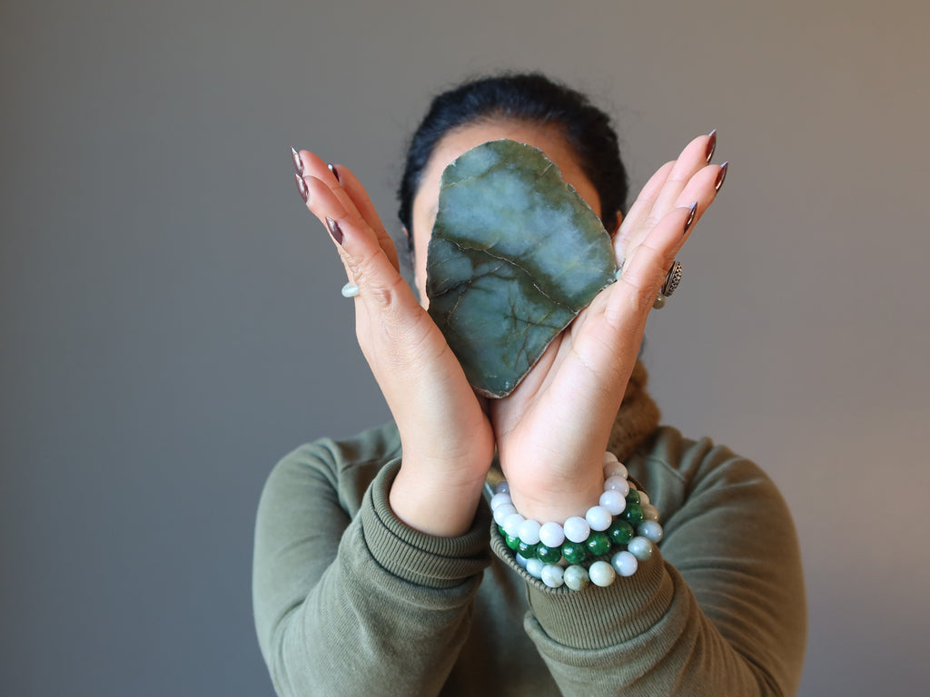 woman holding jade stone and wearing jade bracelet