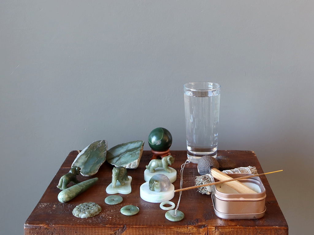 jade stones, glass of water, moqui marbles, candle, cleansing set for meditation