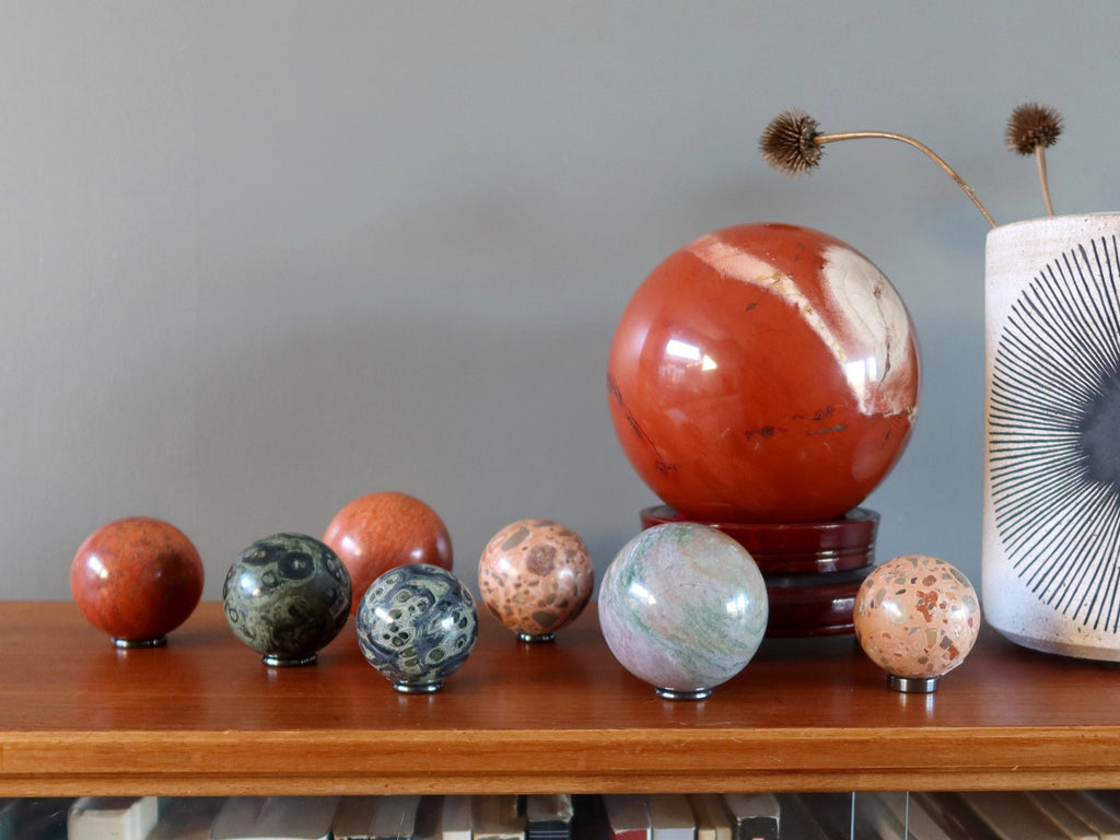 an array of jasper spheres on a bookshelf