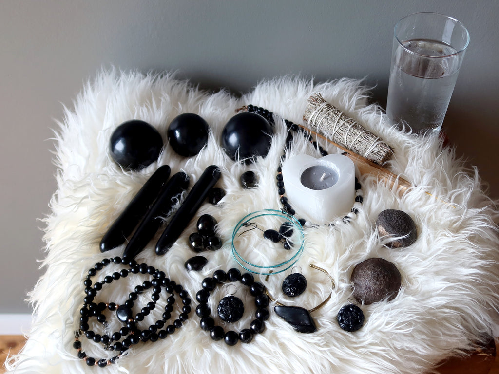 jet stones and jewelry laid out on a sheepskin rug for meditation