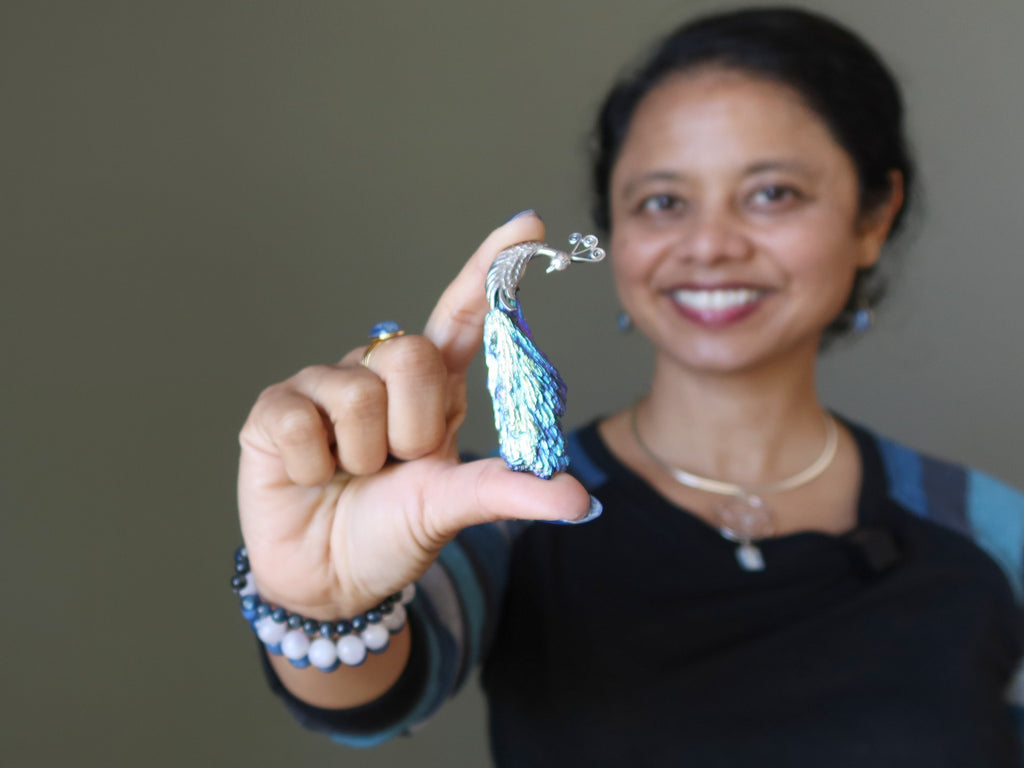 woman holding kyanite peacock pendant