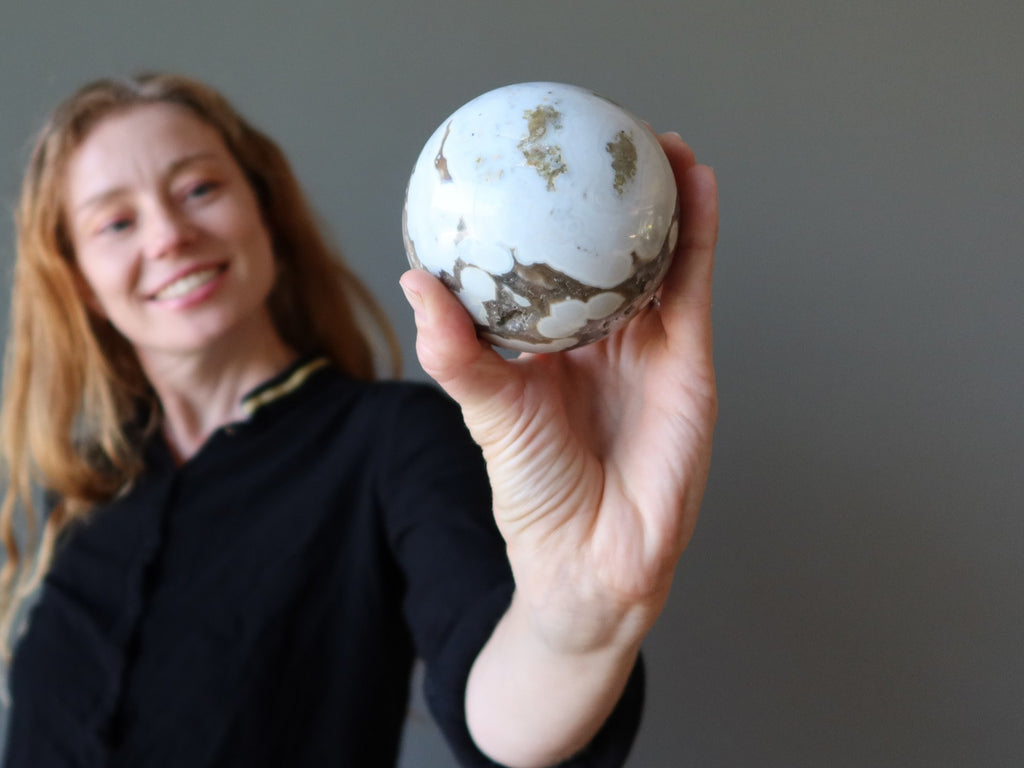 woman admiring ocean jasper sphere