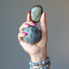 hand wearing and holding labradorite stones