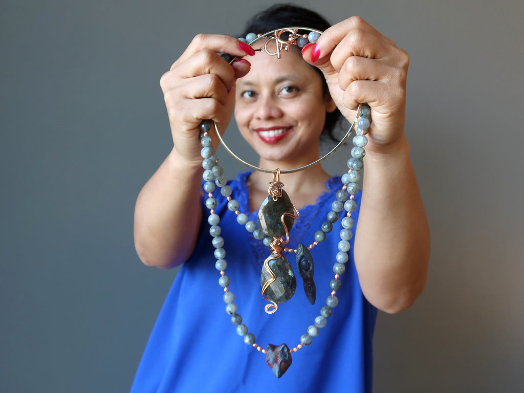 sheila of satin crystals holding up three labradorite necklaces