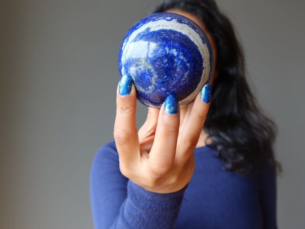 sheila of satin crystals holding up a lapis lazuli sphere