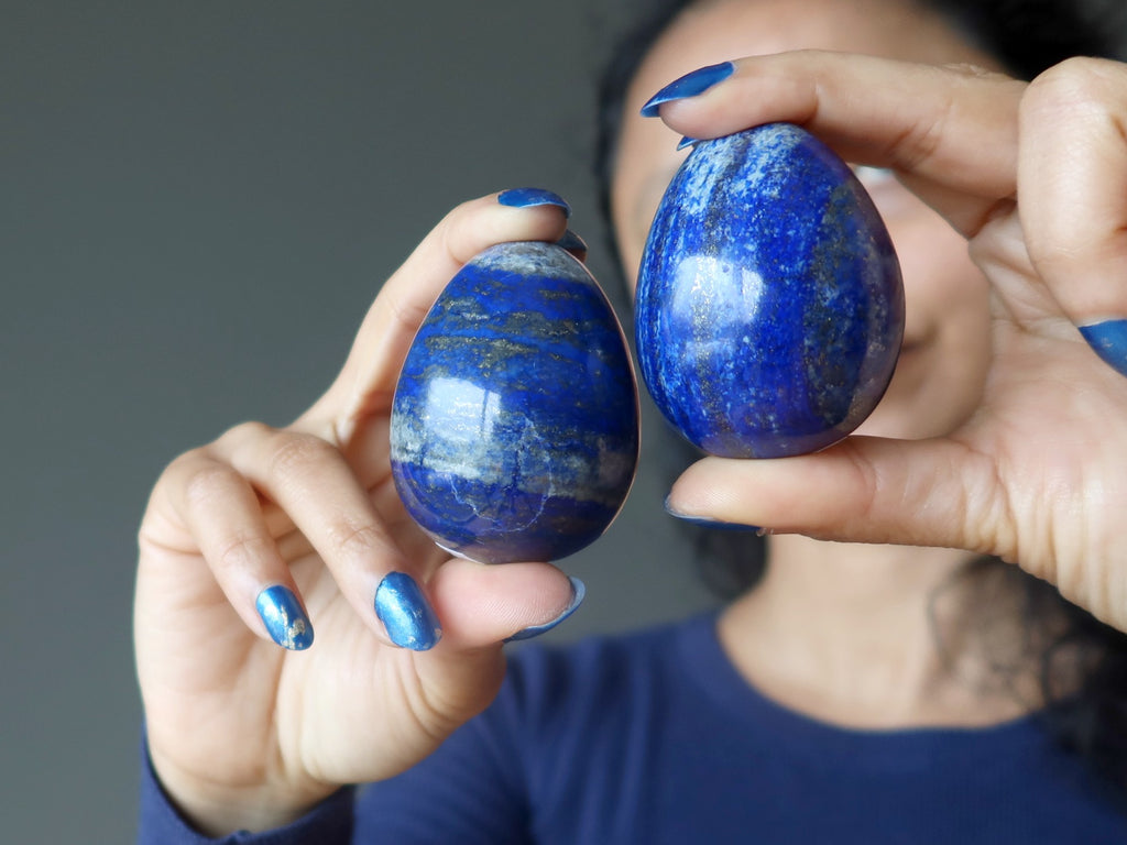 sheila of satin crystals holding up two lapis lazuli eggs
