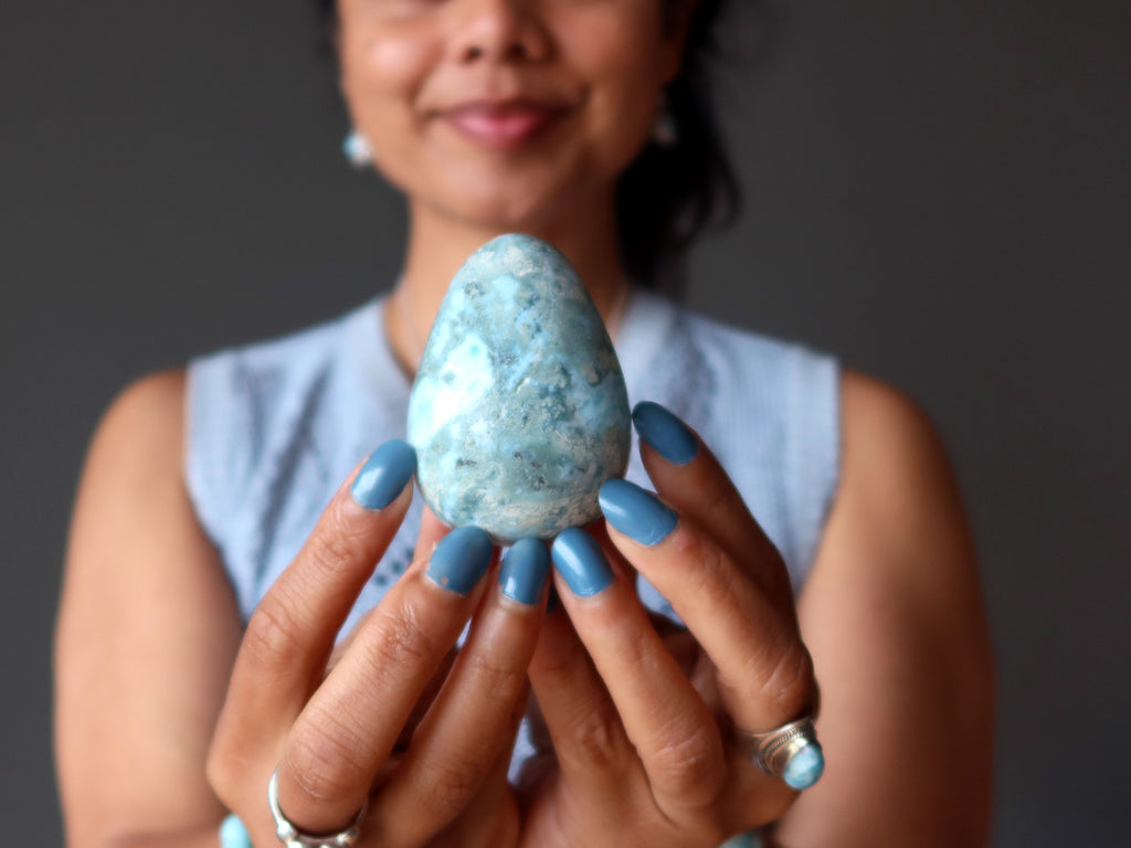 person holding larimar egg