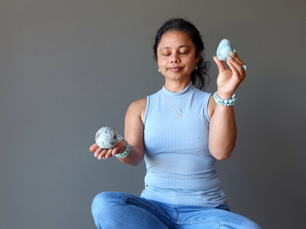 woman meditating with larimar sphere and egg