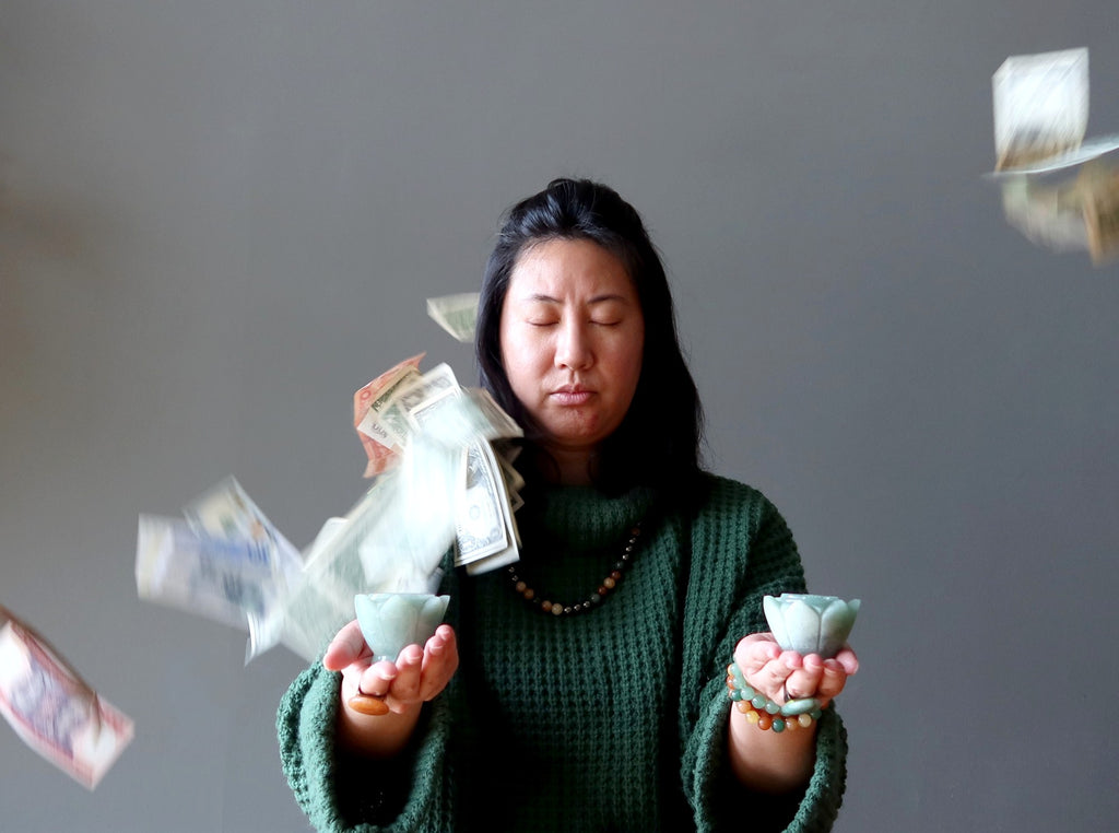 woman meditating with aventurine and money