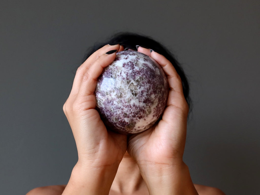 woman holding lepidolite sphere