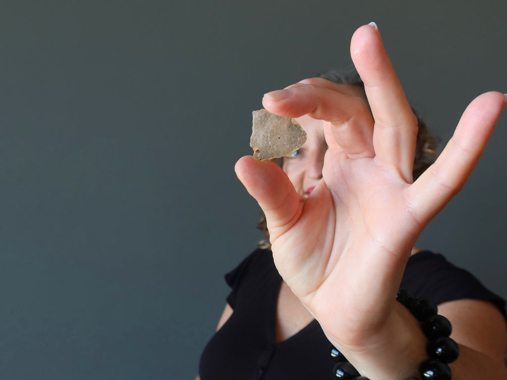 female holding up yellow libyan desert glass for affirmations