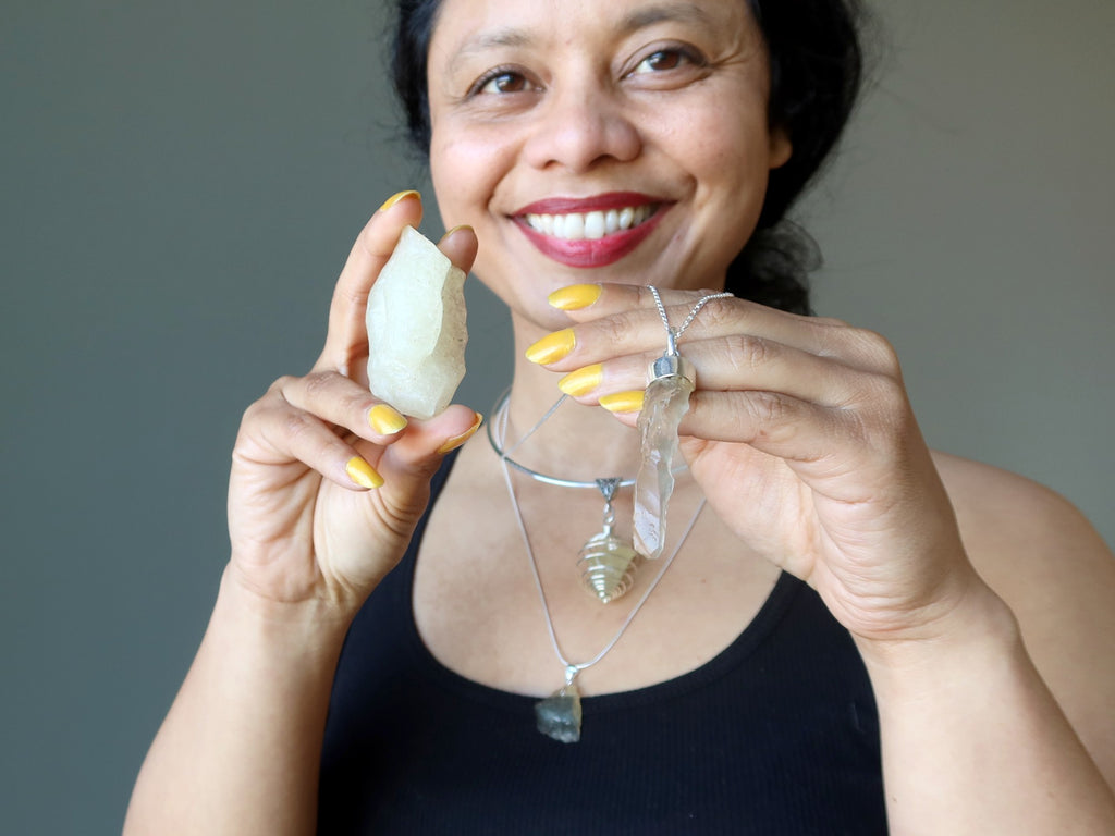sheila of satin crystals holding and wearing yellow libyan desert glass tektite jewelry and gemstones