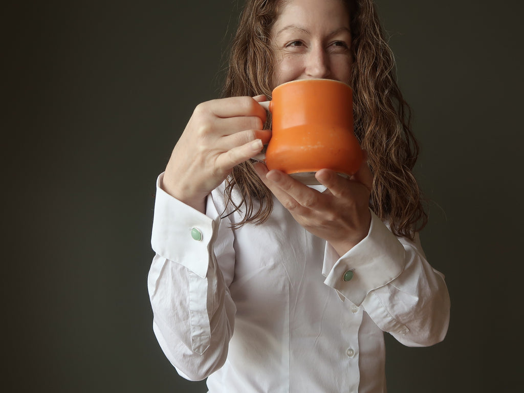 woman with coffee mug wearing aventurine cufflinks