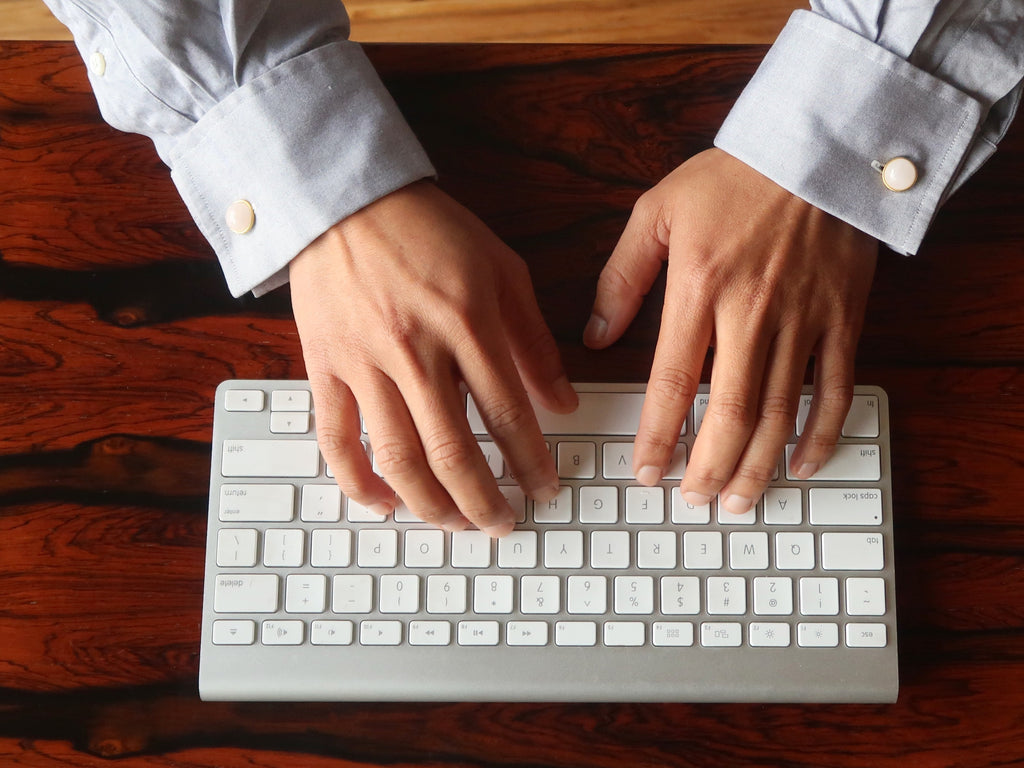 typing on keyboard wearing rose quartz cufflinks