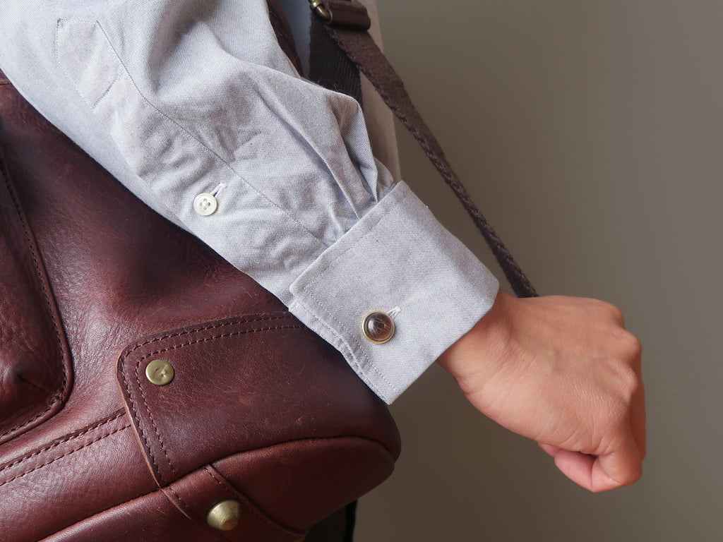 wearing tigers eye cufflinks holding backpack strap