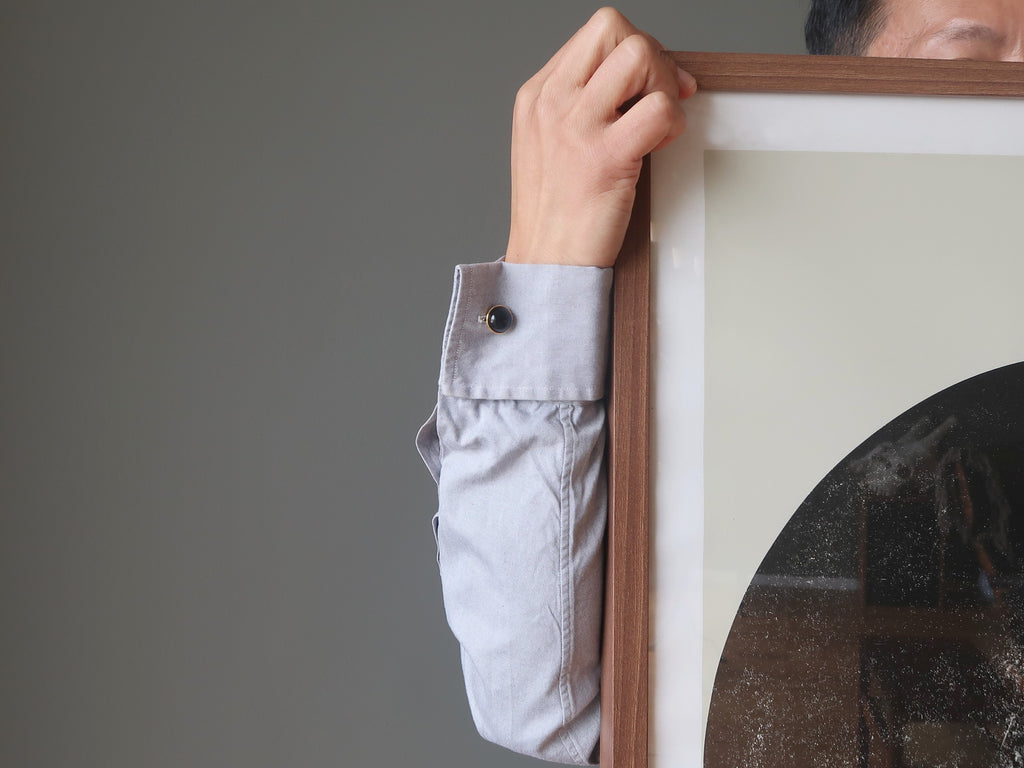 man standing behind artwork wearing onyx cufflinks