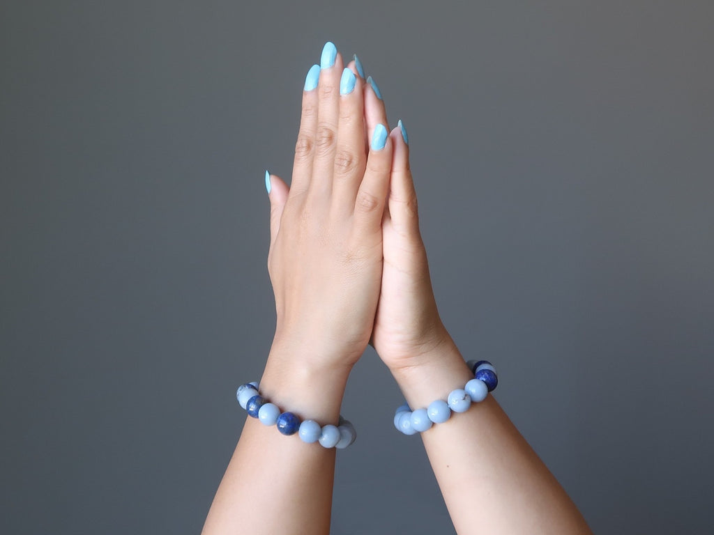 hands in meditation wearing lapis and angelite stretch bracelets