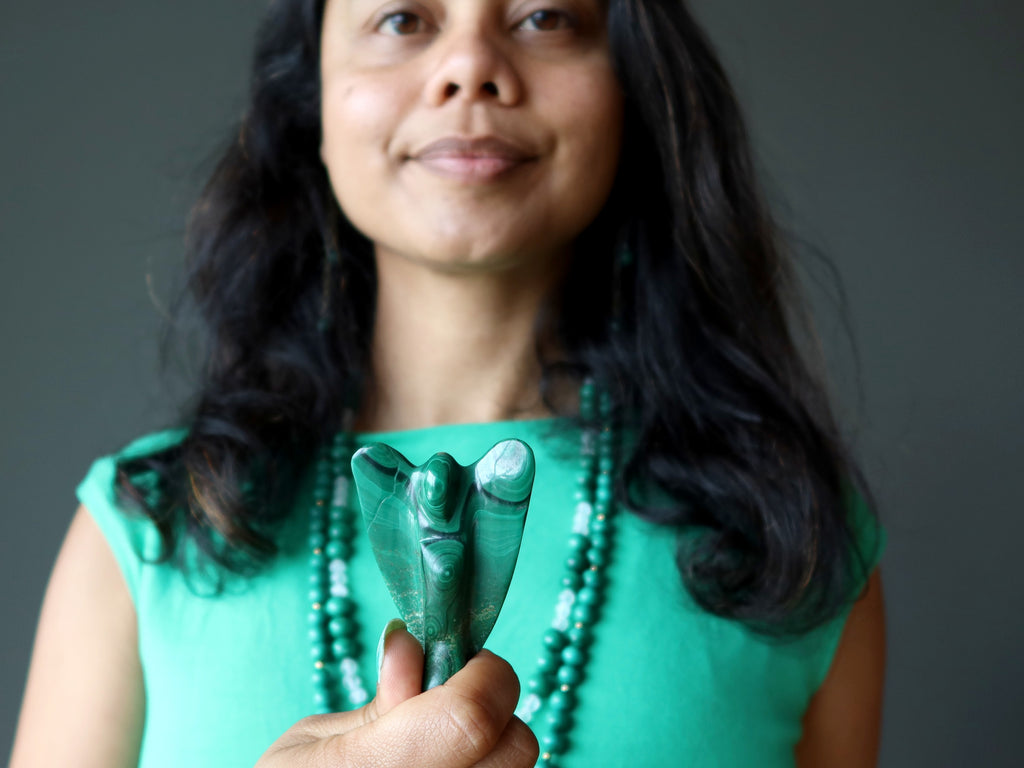 sheila from satin crystals holding up a malachite angel at her heart chakra