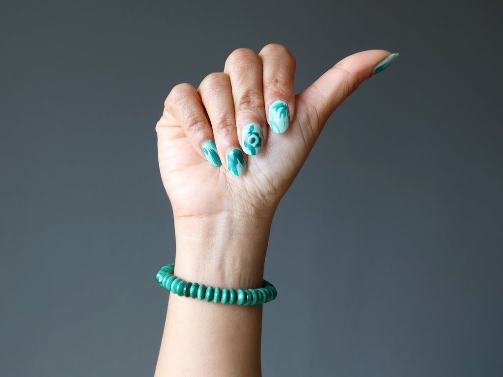 hand wearing malachite stretch bracelet