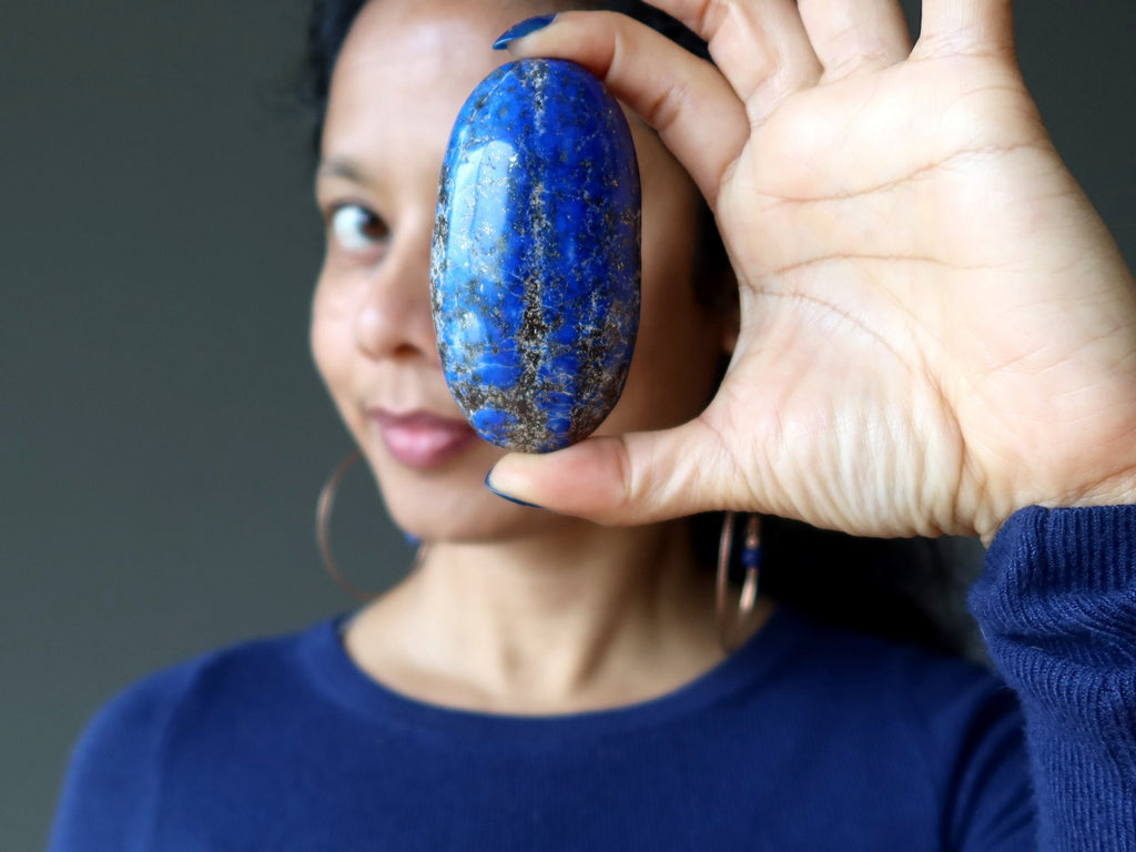 sheila of satin crystals holding up a lapis palm stone