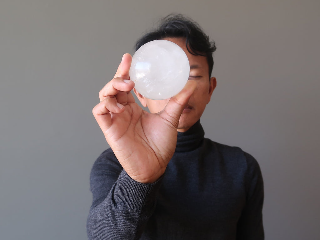 tim of satin crystals meditating with a quartz sphere