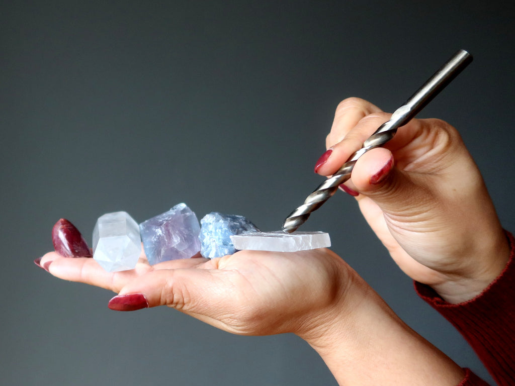 hand holding crystals to be scratched by a drill bit